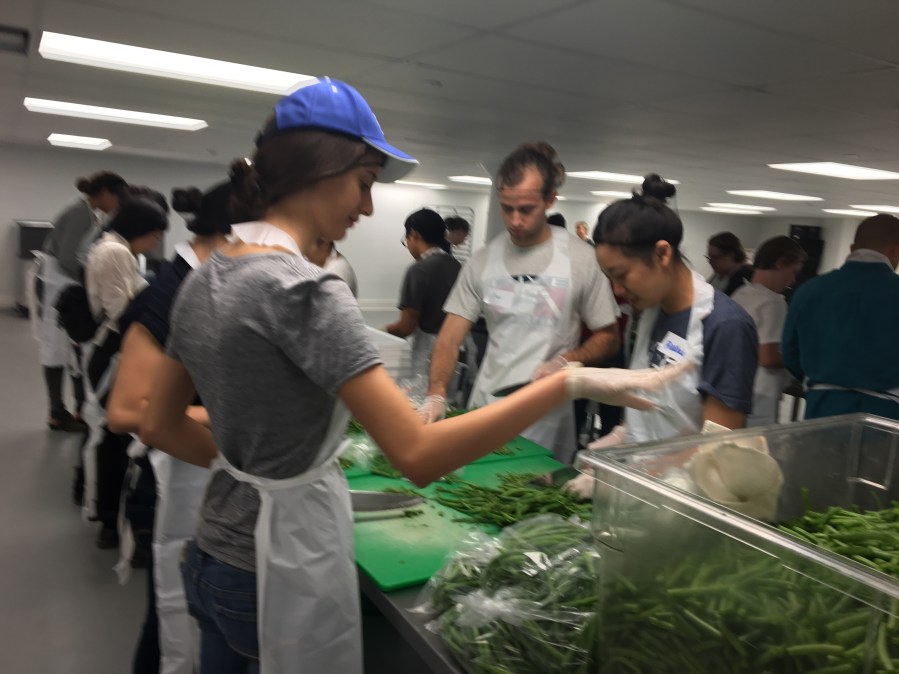 Penn Serves LA chopping green beans at L.A. Kitchen